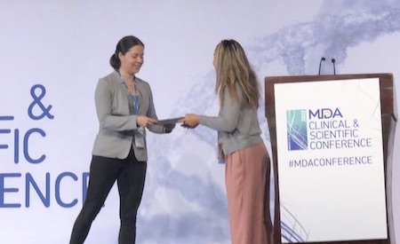 two women on a stage shaking hands