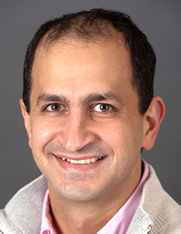 John Kheir, a man with dark hair stares at the camera for his headshot.