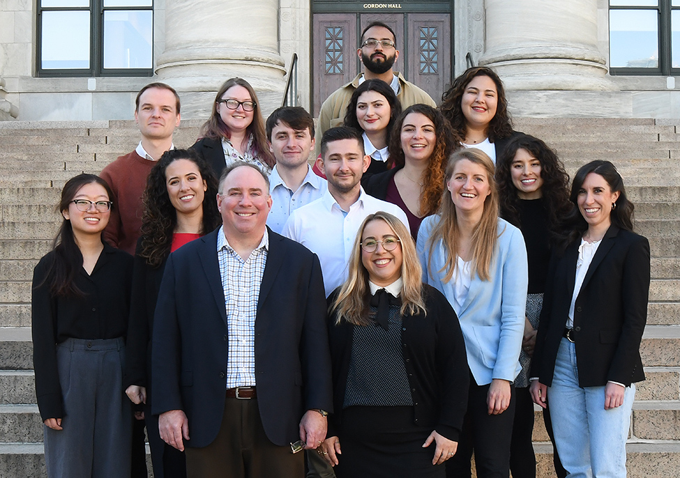 fifteen men and women lab members standing outside building